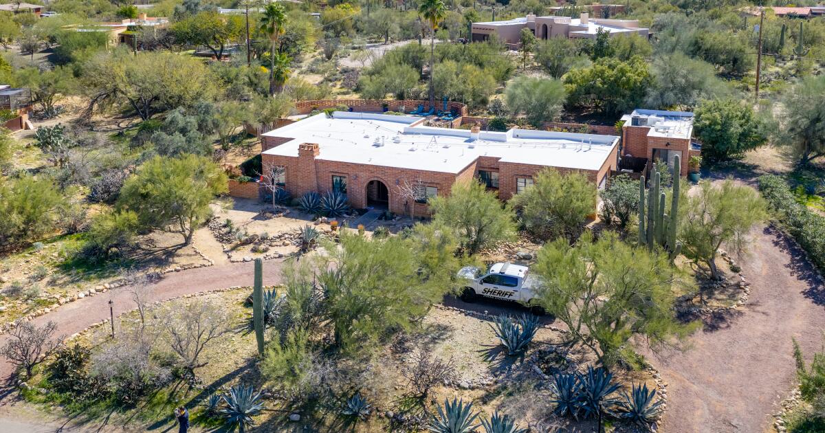 Aerial view of a residential property and surrounding neighborhood during daylight