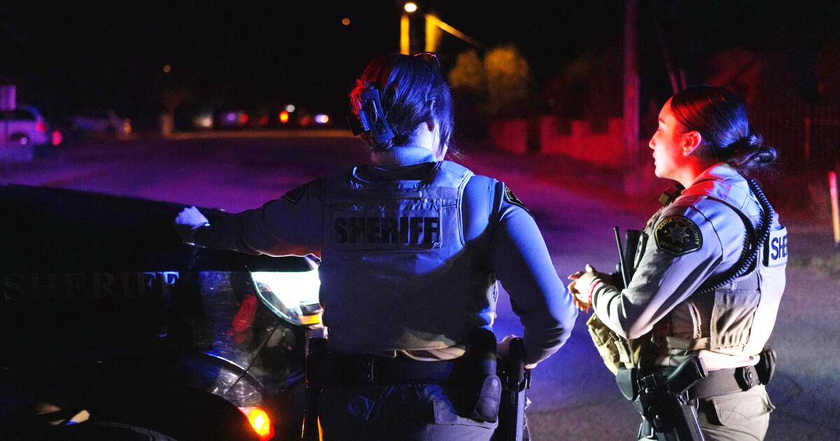 Official speaking at podium with Nancy Guthrie case information displayed on screen behind