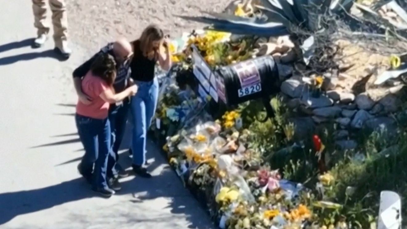Law enforcement personnel conducting ground search of rural/wooded terrain with brush and scattered vegetation